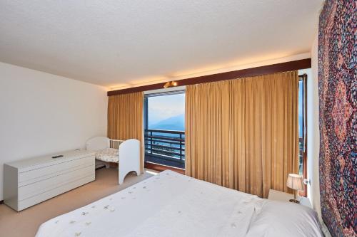 a bedroom with a bed and a large window at Supercrans, Rte de la Tour 10, Superb View!! in Crans-Montana