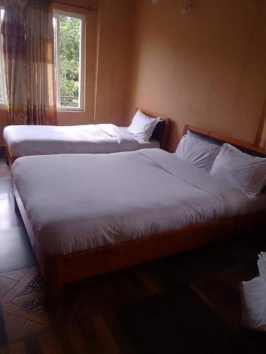 2 camas en un dormitorio con ventana en Hotel Pacific Pokhara, en Pokhara