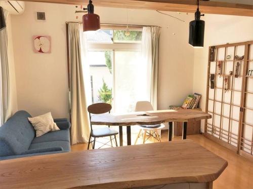 a living room with a blue couch and a table at Tsushima White House in Tsushima