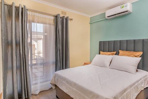 1 dormitorio con cama y ventana en Oh Wine at Luca's Place, en Blantyre