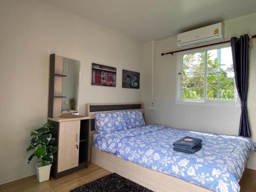een kleine slaapkamer met een bed en een raam bij วิวเขื่อน โฮมสเตย์ 