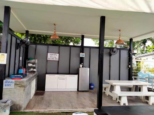 een patio met een witte koelkast en een tafel bij วิวเขื่อน โฮมสเตย์ 