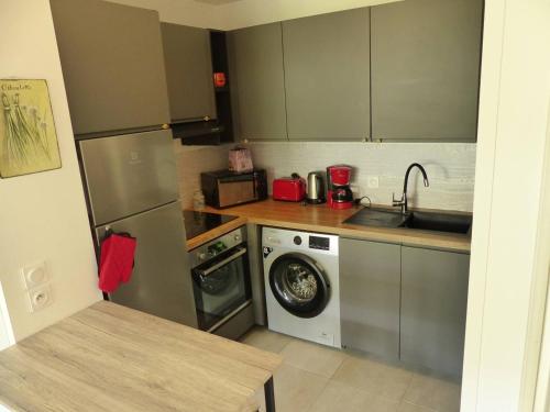 une cuisine avec un évier et une machine à laver dans l'établissement Residence Coeur boise appartement avec terrasse et wifi Espace vert, à Capbreton