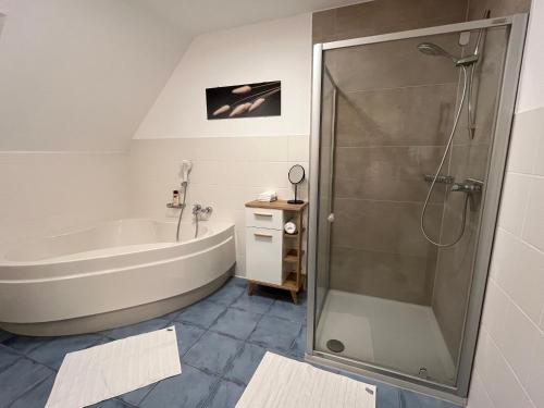 La salle de bains est pourvue d'une baignoire et d'une douche. dans l'établissement FeWo 1 an der historischen Bahnlinie, à Leutkirch im Allgäu