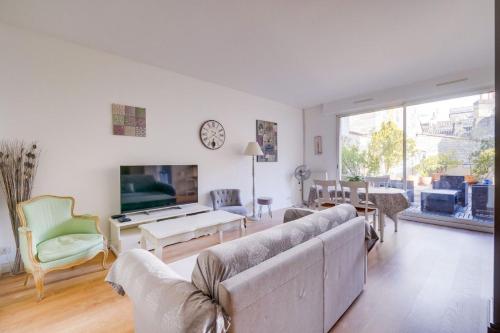 un salon avec des canapés et une télévision dans l'établissement Lovely apartment with exceptional terrace, à Bordeaux