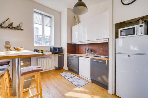 une cuisine avec des armoires blanches et un réfrigérateur blanc dans l'établissement Very nice apartment in the historical center, à Bordeaux