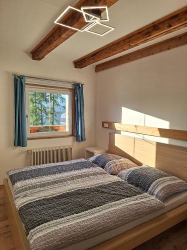 two beds in a bedroom with a window at Lärchenreith Appartement in Schladming