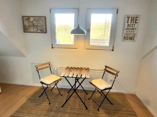 uma mesa e duas cadeiras num quarto em Haus an der Weser - 24/7 Check-In 