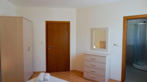 a bedroom with a closet and a dresser and a mirror at Бяла Виста Бийч Апартментс B - Byala Vista Beach Apartments B in Byala