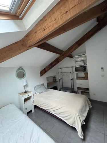 une chambre avec deux lits dans une pièce avec des plafonds en bois dans l'établissement Appartement au cœur d’un village, à Foce