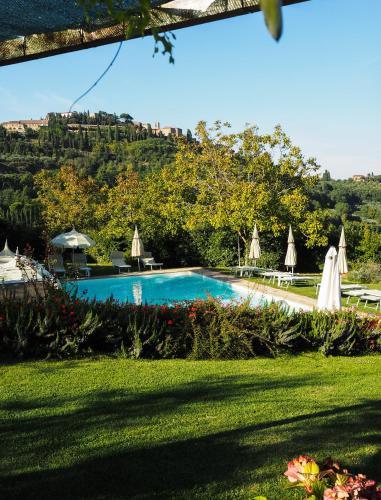 a swimming pool with umbrellas in a yard at Agriturismo Nobile in Montepulciano