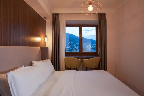 a hotel room with a bed and a window at GM SkyView Luxury Flatiron apartment Skopje in Skopje