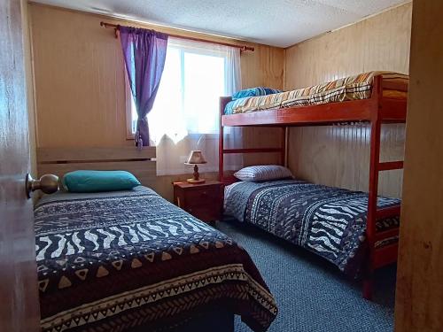 a bedroom with two bunk beds and a window at Cabañas Hornopirén in Hornopiren