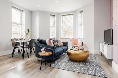 a living room with a blue couch and a table at Tower House Apartments in Bournemouth