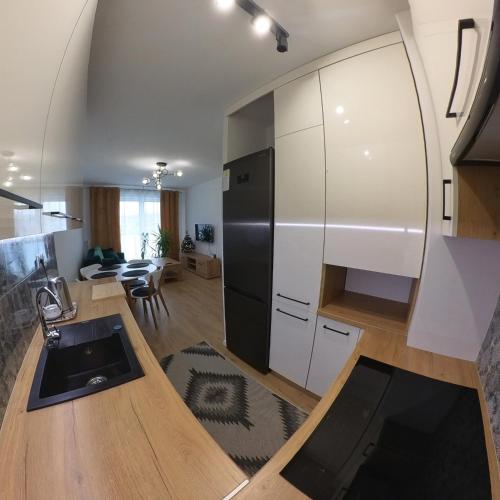 uma cozinha e sala de estar com um frigorífico preto em Apartament Sando em Sandomierz