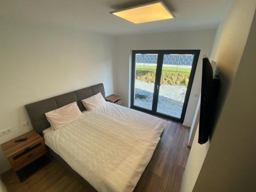 um quarto com uma cama e uma grande janela em Ferienwohnung Kühar em Maishofen
