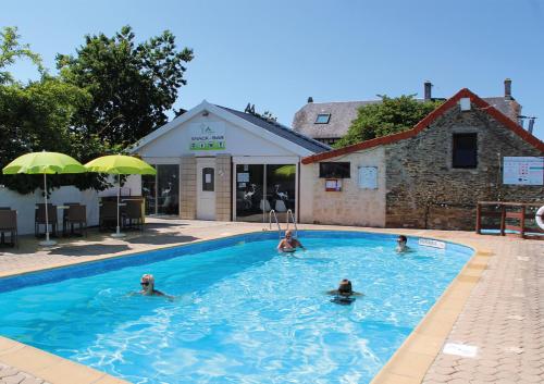 een groep mensen die zwemmen in een zwembad bij Camping Le Picard in Tournières