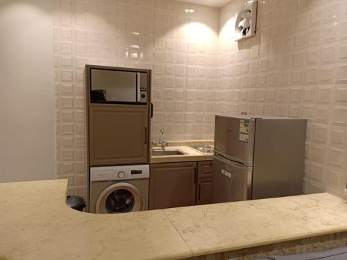 a kitchen with a refrigerator and a washer and dryer at Dorm Story For Hotel Apartment in Taif
