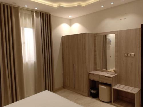 a bathroom with a bed and a sink and a mirror at Dorm Story For Hotel Apartment in Taif