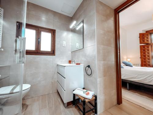 a bathroom with a sink and a toilet and a bed at Fee4Me La Azotea de Morata in Morata de Tajuña