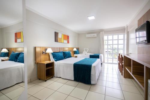a hotel room with two beds and a television at DIROMA EXCLUSIVE - BVTUR in Caldas Novas