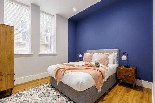 a bedroom with blue walls and a bed at Tower House Apartments in Bournemouth