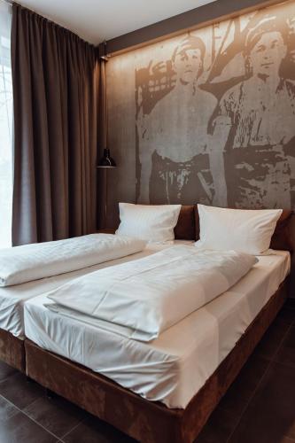 a bedroom with two beds and a painting on the wall at Encanto Hotel Restaurant in Balingen