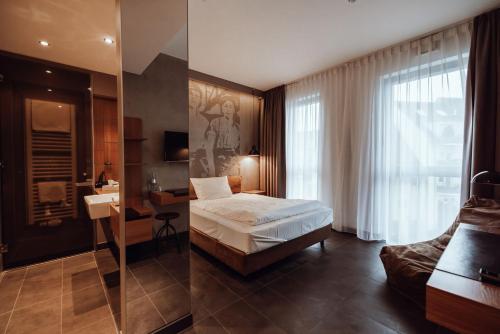 Schlafzimmer mit einem Bett, einem Schreibtisch und einem Spiegel in der Unterkunft Encanto Hotel Restaurant in Balingen