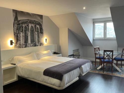 1 dormitorio con cama extragrande y mesa en Hotel Gran Regente, en Oviedo