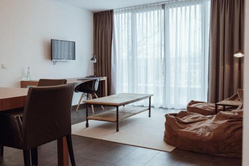 - un salon avec une table et un canapé dans l'établissement Encanto Hotel Restaurant, à Balingen