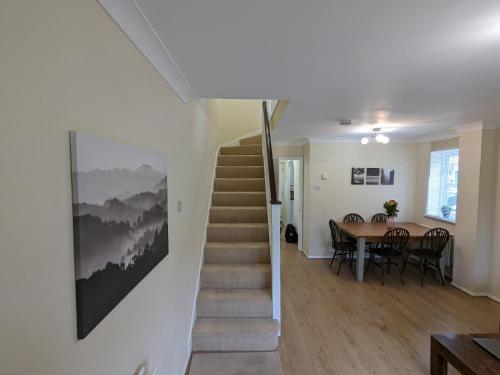 a staircase in a house with a table and a dining room at Guildford Townhouse with Parking in Guildford