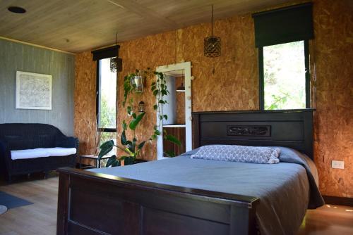 a bedroom with a bed in a room with wooden walls at Glamping con jacuzzi cerca a Medellin in Guarne