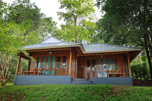 a small wooden house with a metal roof at Royal Wooden villa in Mananthavady