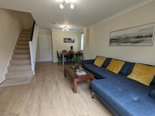 a living room with a blue couch and a table at Guildford Townhouse with Parking in Guildford