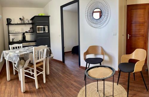 une cuisine et une salle à manger avec une table et des chaises dans l'établissement Appartements de la houle, à Cancale