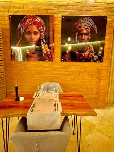 a dining room with a table and a picture of a woman at Le Patio in Lomé