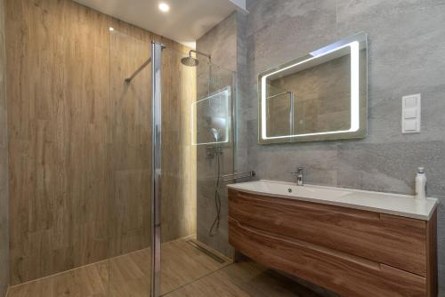 uma casa de banho com um chuveiro, um lavatório e um espelho. em Apartments Sorić em Trogir