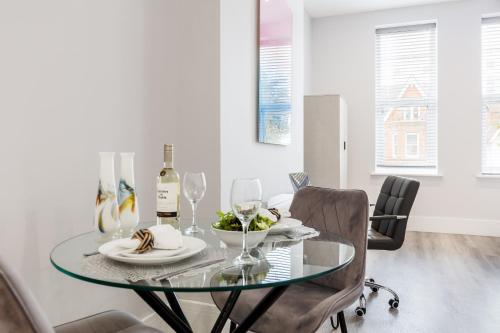a dining room with a glass table and chairs at Tower House Apartments in Bournemouth