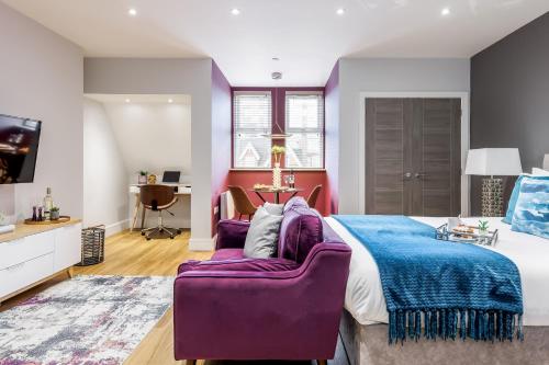 a bedroom with a purple bed and a purple chair at Tower House Apartments in Bournemouth