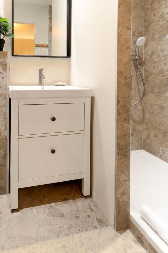 a bathroom with a white sink and a shower at Appart Hôtel Coraline - Genas Lyon Eurexpo in Genas