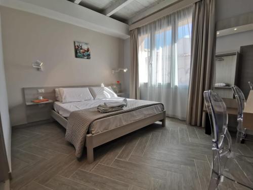 a bedroom with a bed and a large window at Green Guest House in Oristano