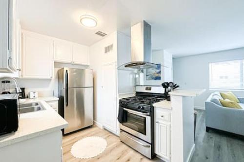 cocina con fogones de acero inoxidable y nevera en Dual-Level Delight 2BR in Hollywood - BR4-BH en Los Ángeles