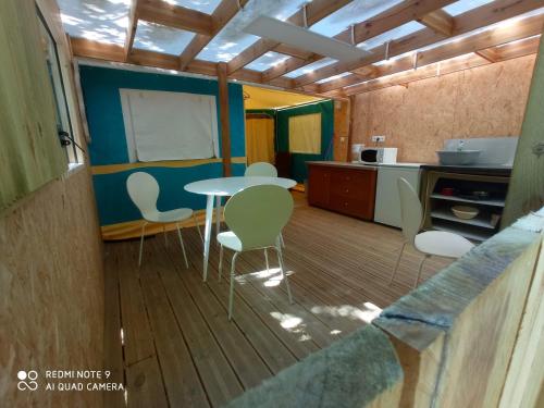 uma cozinha com mesa e cadeiras num quarto em Tente aménager 4 personnes em Saint-Gildas-de-Rhuys
