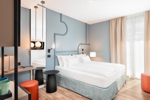 una camera d'albergo con letto e scrivania di HT Hotel Trieste a Gradisca dʼIsonzo