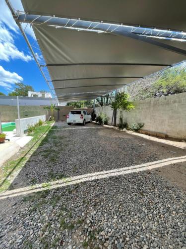 ein Auto, das auf einem Parkplatz unter einem Baldachin parkt in der Unterkunft Hotel Boutique in Mina Clavero