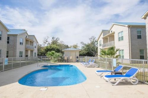 a swimming pool in a courtyard with chairs and condos at Fins Up in Long Beach