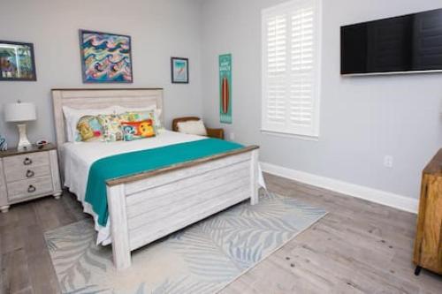 a bedroom with a bed and a flat screen tv at Fins Up in Long Beach