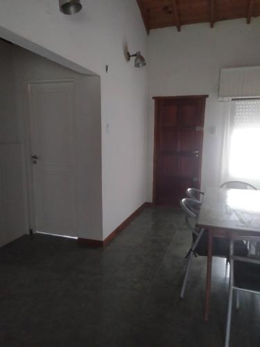 a room with a table and chairs and a door at Casa Chalet Lamar alojamiento entero in Santa Clara del Mar