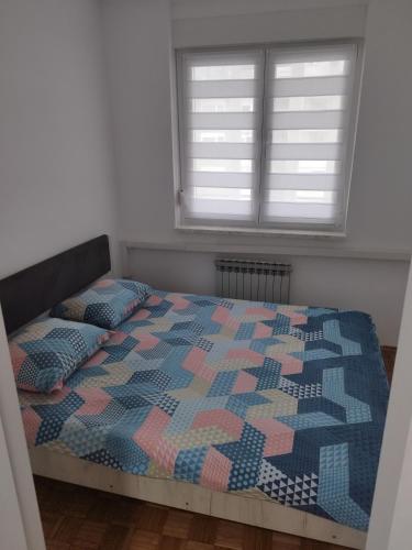 a bedroom with a bed with a quilt on it at Apartman N&D in Banja Luka