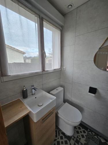 La salle de bains est pourvue de toilettes, d'un lavabo et d'une fenêtre. dans l'établissement Chambre indépendante, privée climatisée avec parking, à Montauban